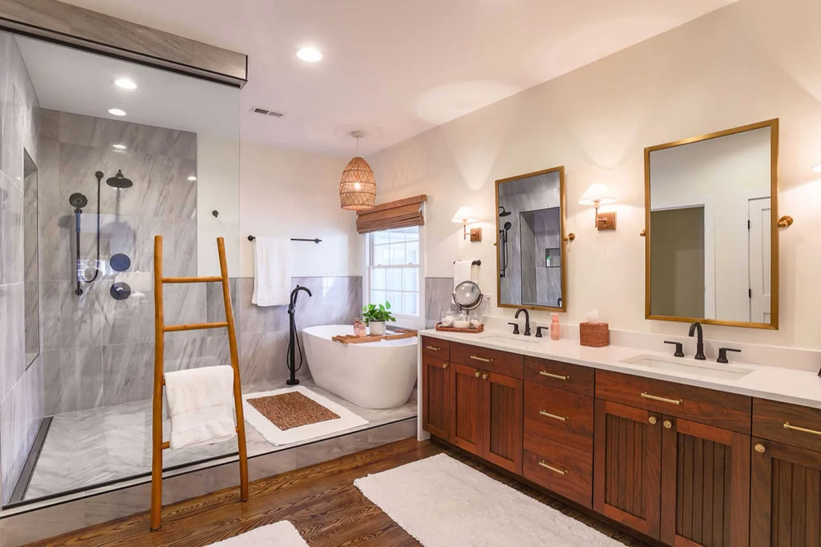 Renovated primary bathroom with a freestanding tub, walk-in shower and walnut vanity