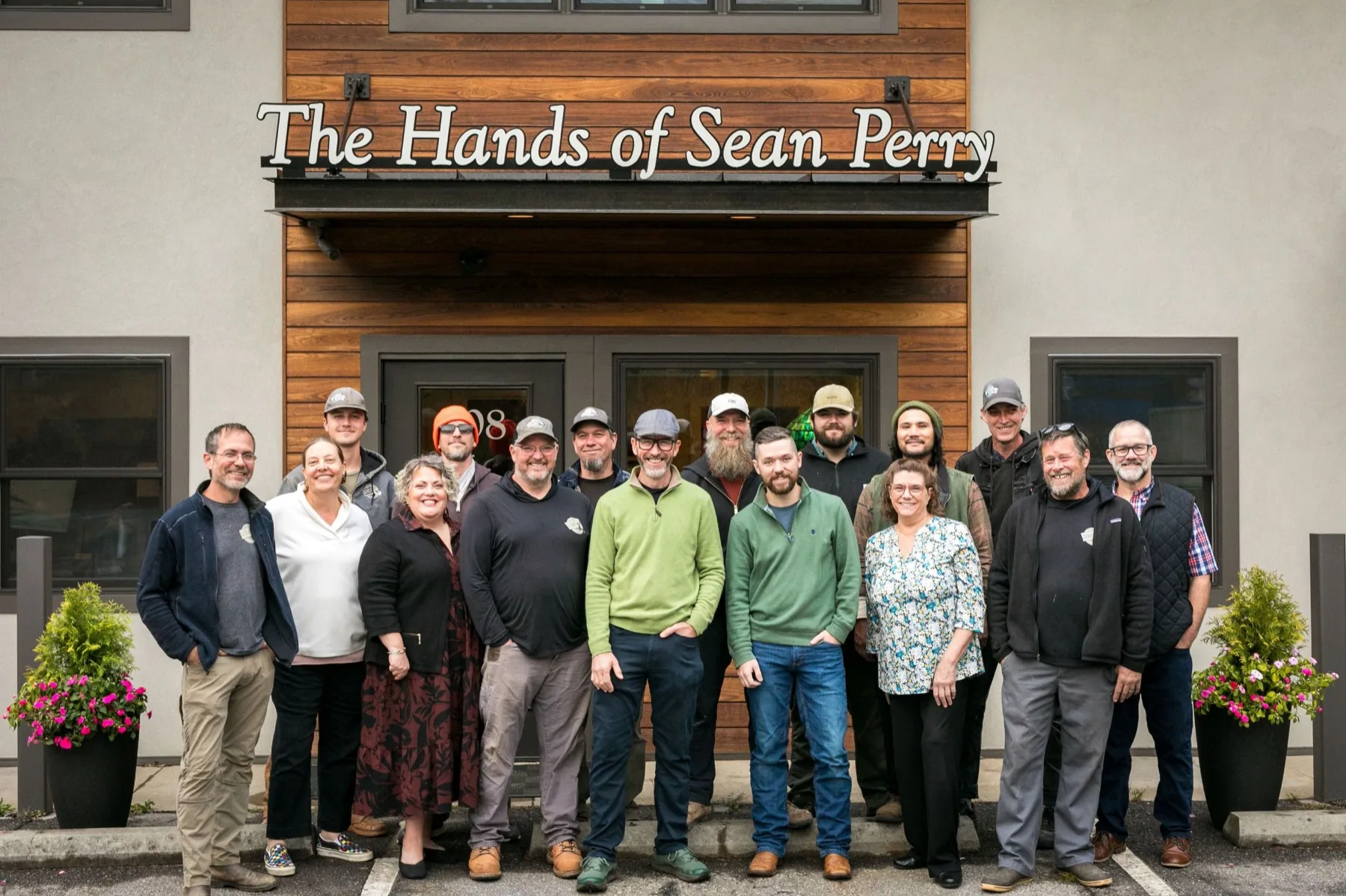 The Hands of Sean Perry team gathered outside the company office on Merrimon Avenue in Asheville