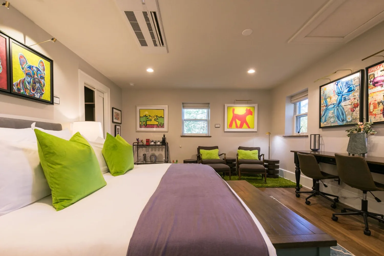 Guest bedroom with bright pop art on the walls, green accent pillows and a built-in desk